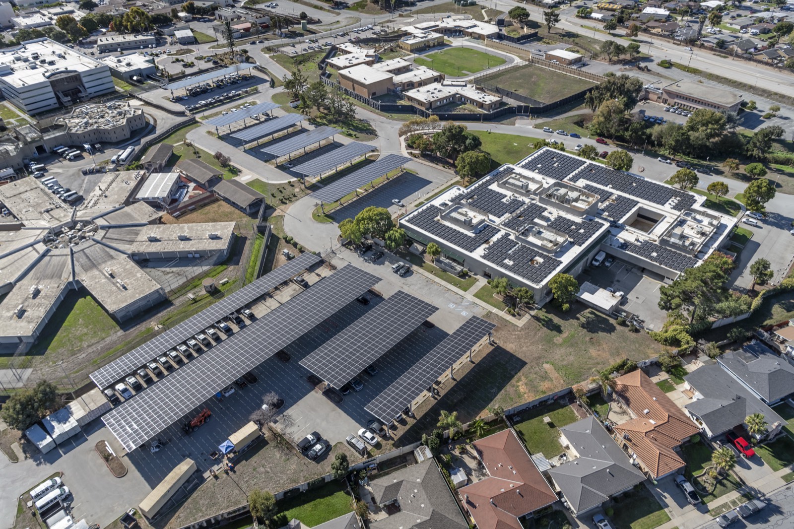 Aerial view of a MYNT commercial project: rooftop solar on the building with solar carports across the parking lots
